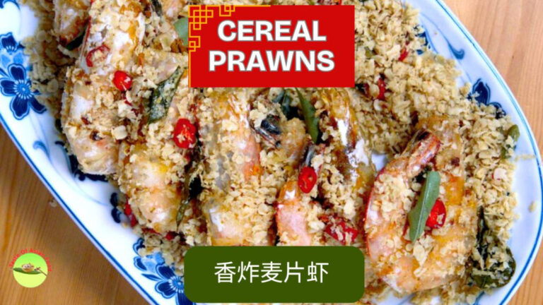 A vibrant plate of Malaysian cereal prawns, crispy and golden, garnished with fresh curry leaves and ready to serve.
