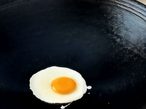 The fried egg does not stick to a well-seasoned wok, even though there is no oil added.