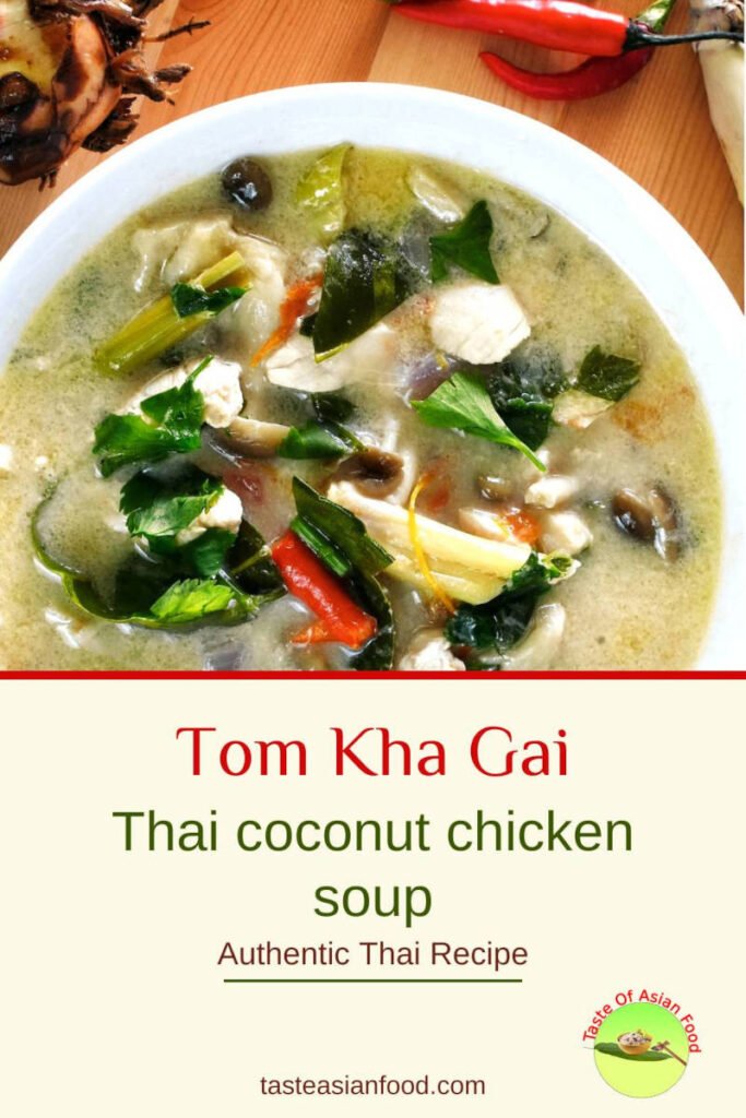 Bowl of authentic Tom Kha Gai Thai coconut chicken soup topped with fresh herbs and lime wedges