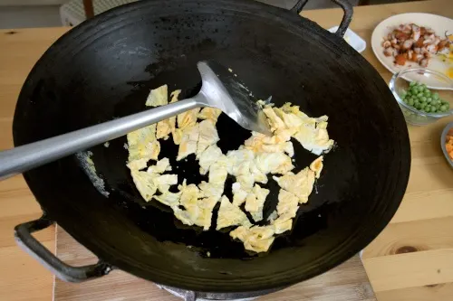 Use a spatula to break the eggs into small pieces.