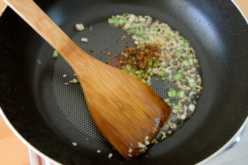 saute the dried chili, spring onions, ginger, and garlic over low heat until aromatic.