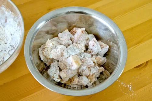 Coat the pork with a mixture of starch and regular flour before deep-frying. The deep-fry until golden.
