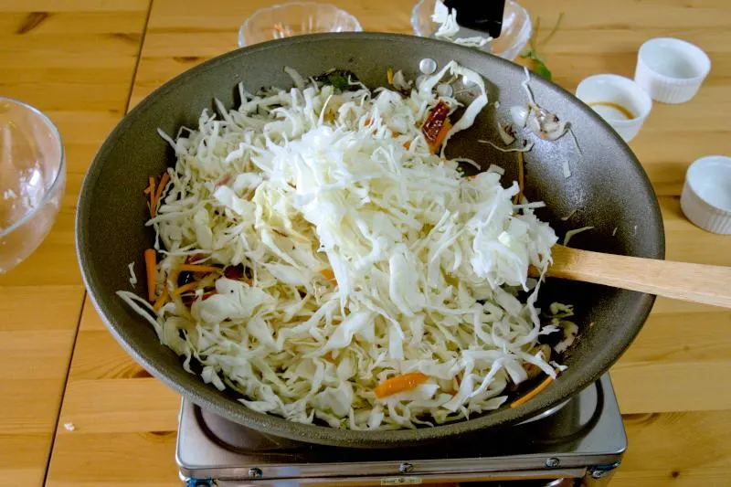  Add the cabbage to the wok and stir-fry over medium to high heat until they become soft.