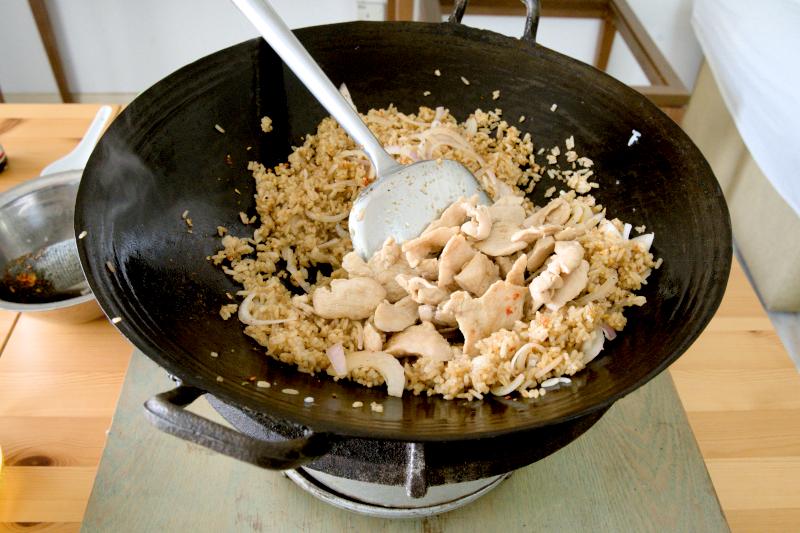 Return the cooked rice and chicken to the wok.