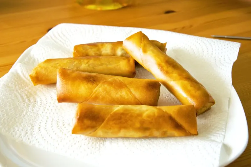 Place the spring rolls on a piece of paper towel to remove the excess oil after deep frying.