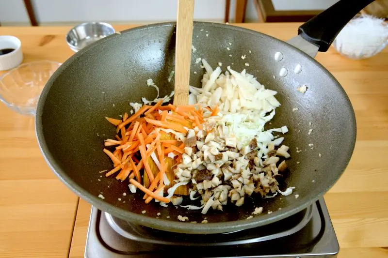 To prepare the ingredients for the spring roll, stir-fry the mushroom and other vegetables (except the spring onion) with the remaining oil