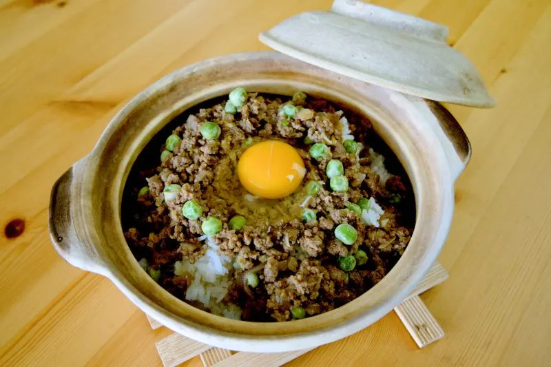 Crack an egg in the middle of the spread of the ground beef. 