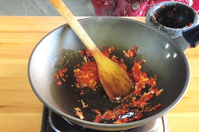 Heat some oil in a wok and start sautéing the chili and garlic until they become fragrant. 