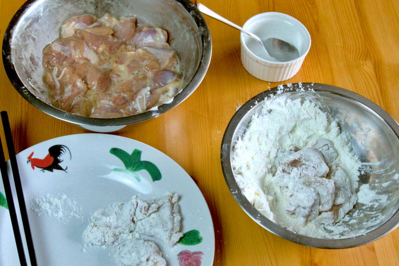 Dip the marinated chicken pieces into the egg white, then coat them generously with cornstarch.