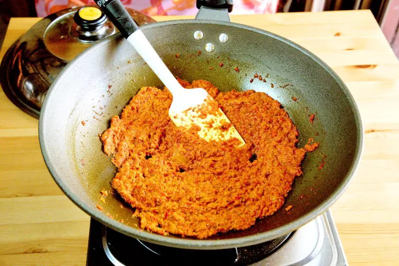 Sauté the spice paste over low heat until it becomes aromatic.