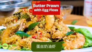 Butter prawns with egg floss in Malaysian restaurant style, crispy golden strands and curry leaves on top