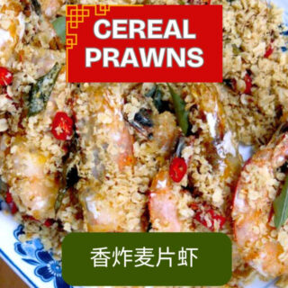 A vibrant plate of Malaysian cereal prawns, crispy and golden, garnished with fresh curry leaves and ready to serve.