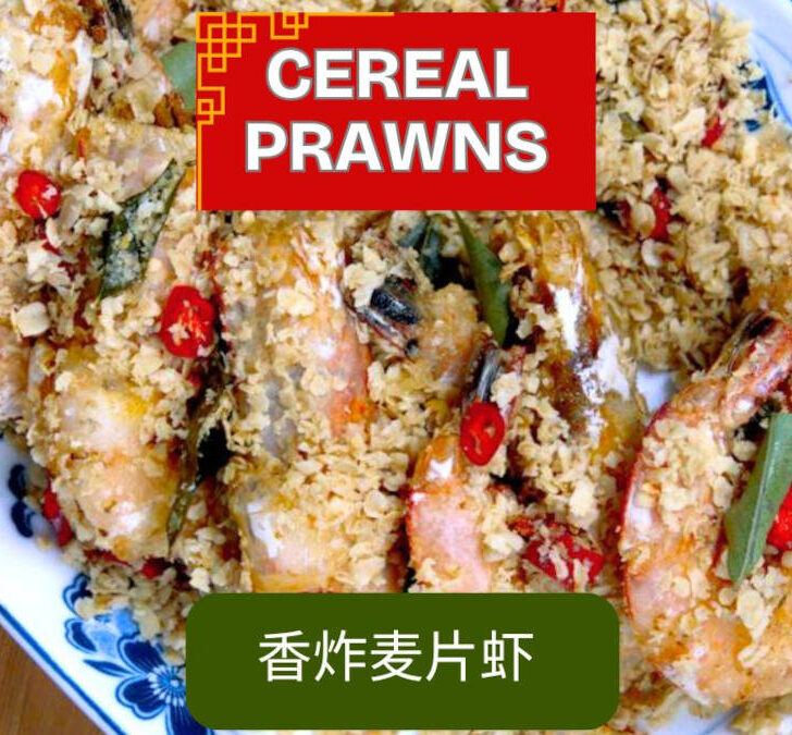 A vibrant plate of Malaysian cereal prawns, crispy and golden, garnished with fresh curry leaves and ready to serve.